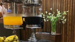 Ein Buffet mit verschiedenen Speisen, darunter Obst, Gebäck und einer Kaffeestation.