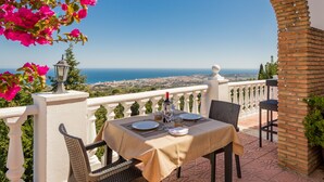 A table set for two with a view of the sea and city in the background. - Macdonald La Ermita Resort (Mijas)
