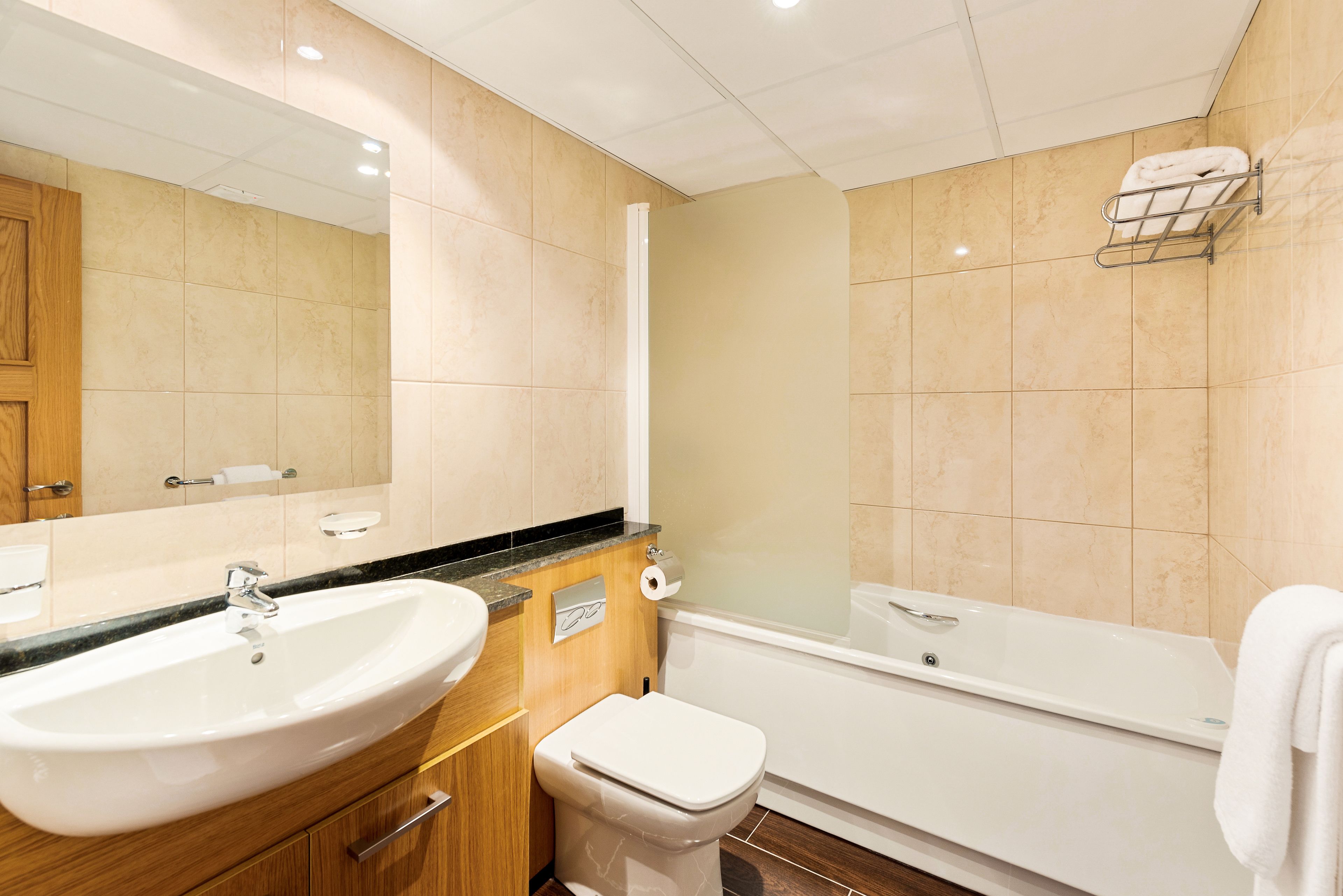 A modern bathroom with a sink, toilet, and bathtub.