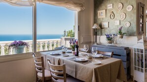 A dining area with a table set for four, overlooking a scenic view of the sea. - Macdonald La Ermita Resort (Mijas)