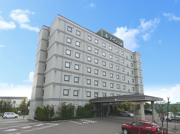 Ein mehrgeschossiges Hotel mit einer glatten Fassade, zahlreichen Fenstern und einem überdachten Eingang.
