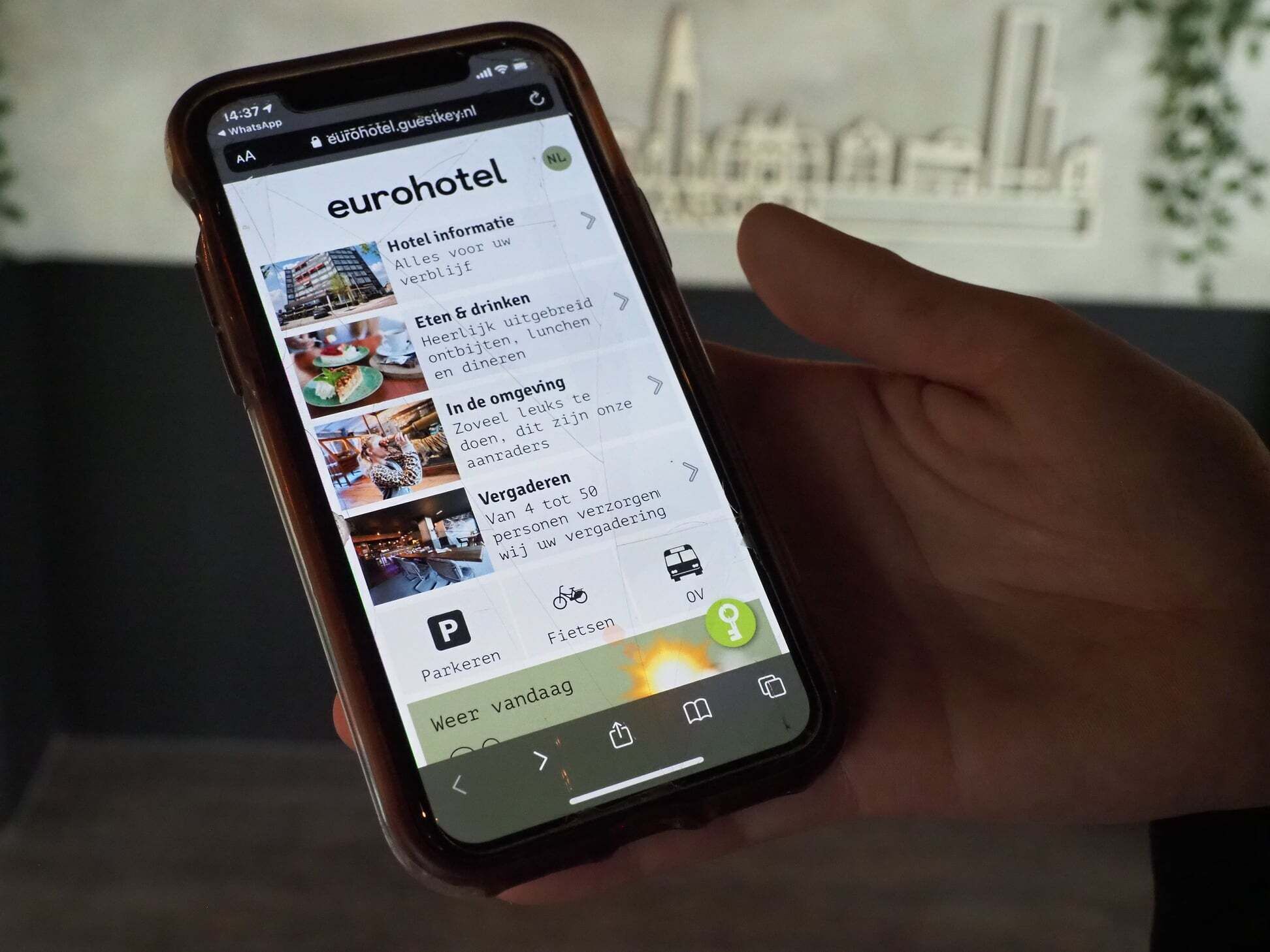 A smartphone displaying the eurohotel website with sections for hotel information, amenities, parking, and a map.