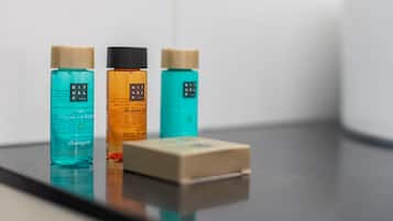 Three bottles of shampoo on a reflective surface.