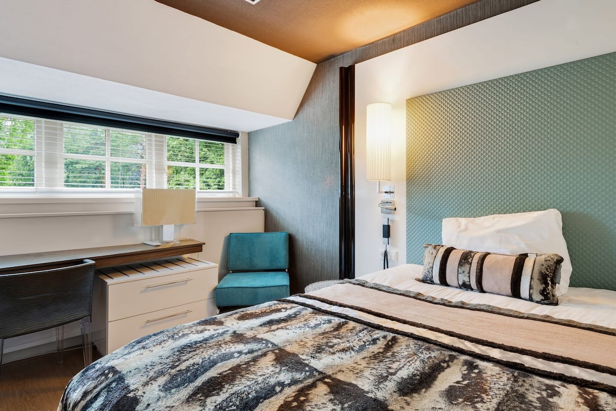 Un dormitorio con cama, escritorio y silla.