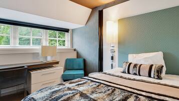 Een slaapkamer met een bed, een bureau en een stoel.