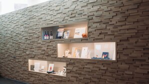 A wall with three illuminated display cases containing various items. - Albion Hotel (Ypres)