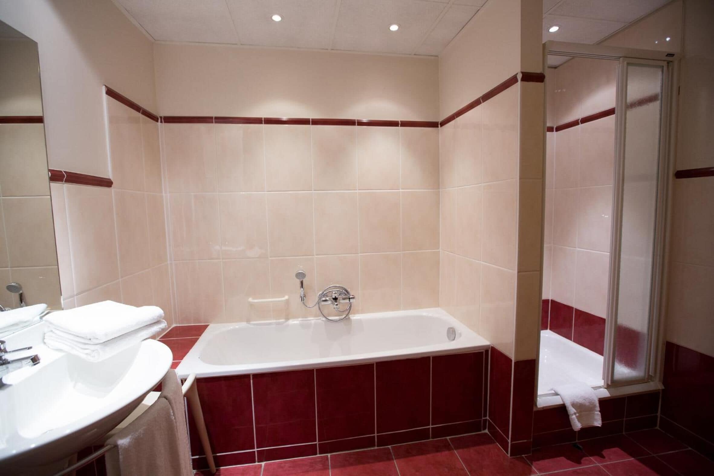 A bathroom with a bathtub, a shower, and a sink.