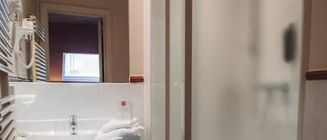 A bathroom with a sink, toilet, and shower.