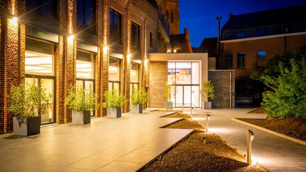 A modern building with a brick facade, large windows, and a well-lit entrance. - Albion Hotel (Ypres)