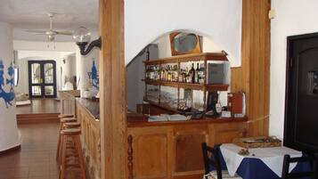 A bar area with wooden furniture, a tiled floor, and a dining table with chairs.