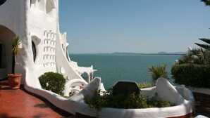 Un edificio bianco con una facciata curva e vista sul mare.