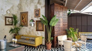 A cozy indoor seating area with a yellow sofa, wooden cabinet, and a dining table with chairs. - Casa Suzanna (Tel Aviv)