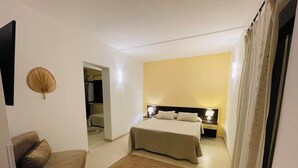 A bedroom with a bed, bedside tables, a nightstand, a sofa, and a small rug. - Il Girasole Capo d'Orlando (Capo d'Orlando)