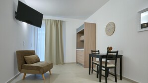 A modern living room with a sofa, a dining table with chairs, a TV mounted on the wall, and a clock. - Il Girasole Capo d'Orlando (Capo d'Orlando)