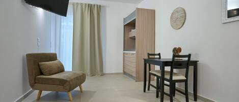 Uma sala de estar moderna com sofá, mesa de jantar e cadeiras, televisão na parede e um relógio.