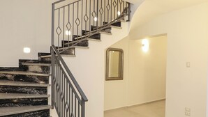 A staircase with black marble steps and a metal railing, leading to a landing with a mirror and a light fixture. - Il Girasole Capo d'Orlando (Capo d'Orlando)