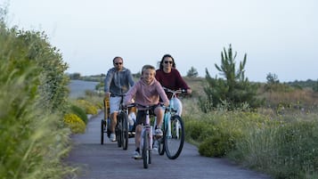 Een groep mensen fietst op een verhard pad, omringd door groen.