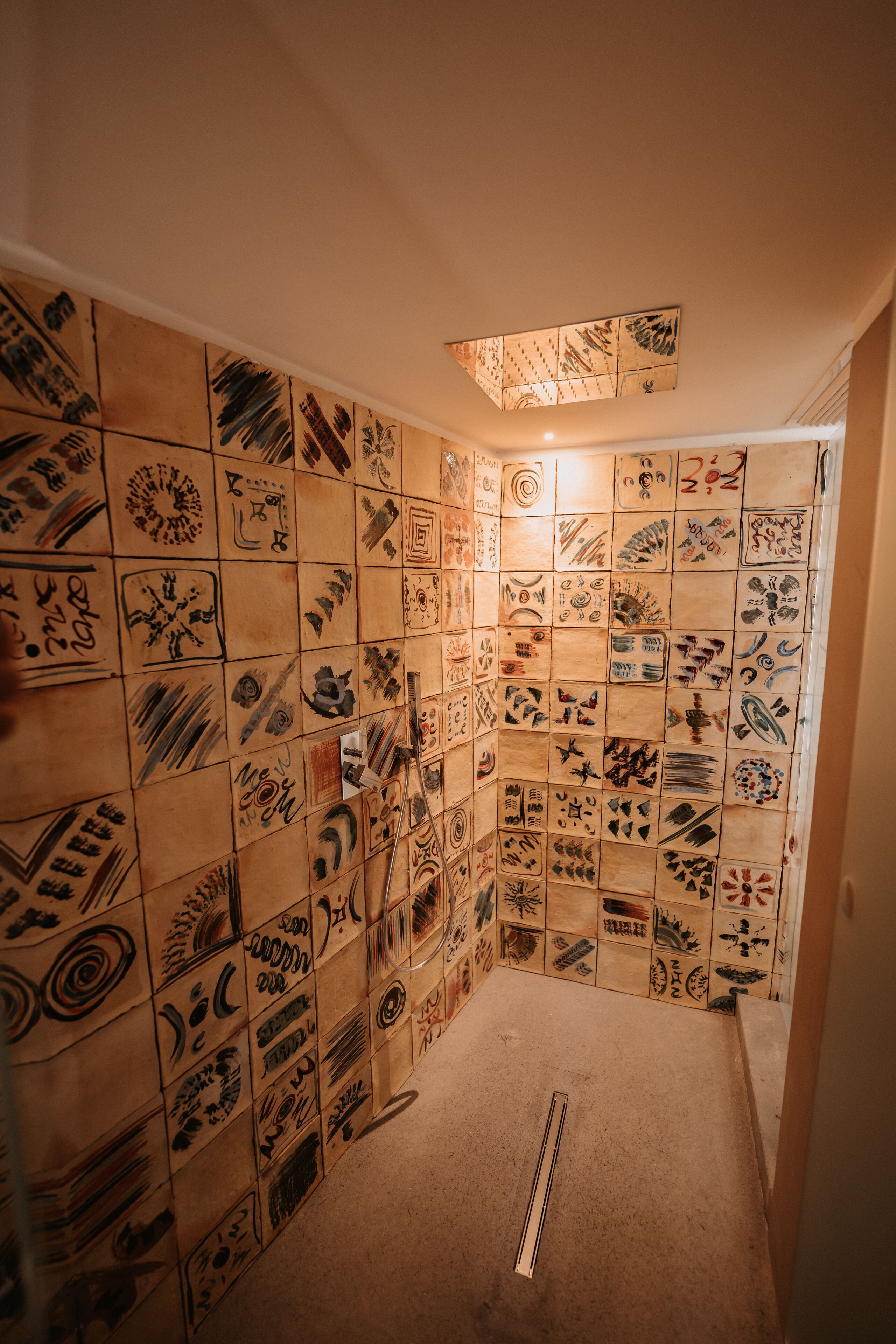 A room with a tiled wall featuring various patterns and designs.