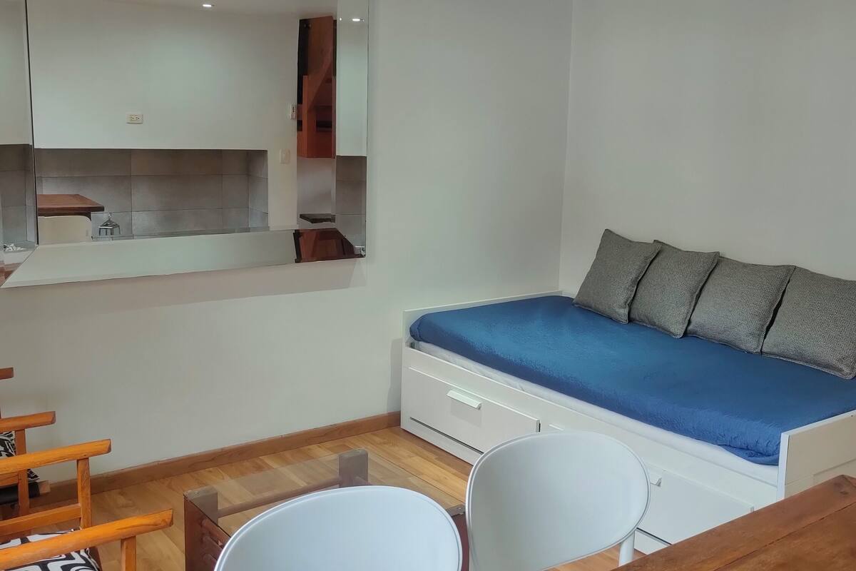 Une chambre à coucher avec un lit, un bureau, une chaise et un miroir.