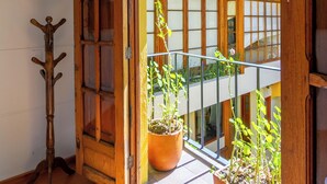 A wooden door leading to a balcony with potted plants.