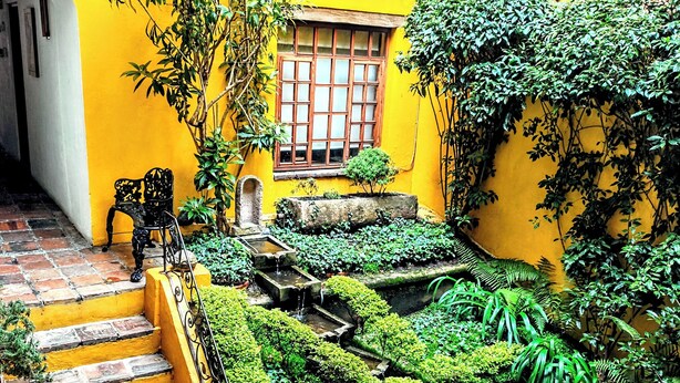 A yellow building with a staircase leading to a window.
