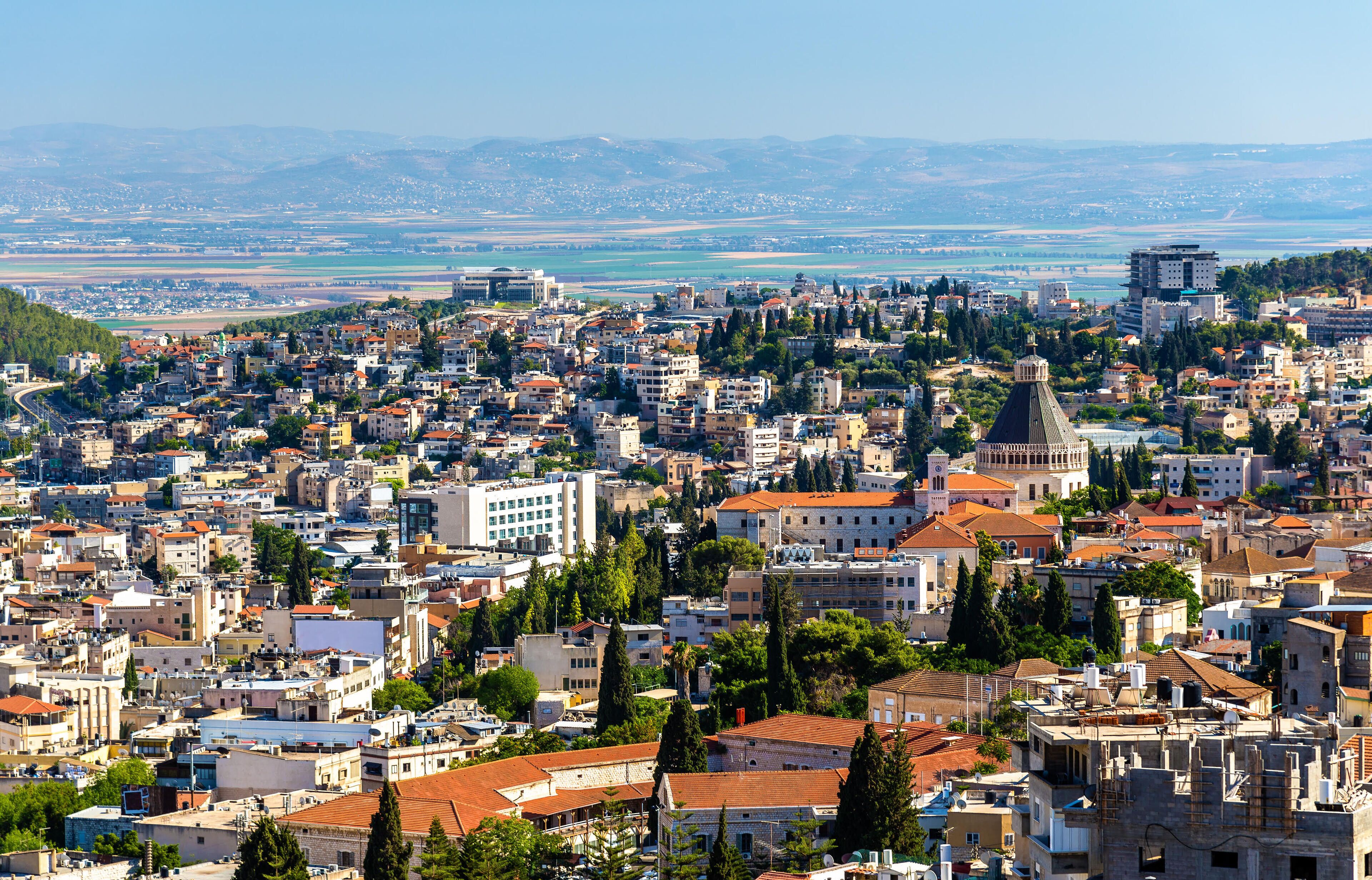 A densely packed urban area with various buildings, including a prominent church with a dome.