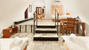 A hotel room with a marble floor, a bed, a desk, a chair, a small table, and a staircase. - Fauzi Azar by Abraham (Nazareth)