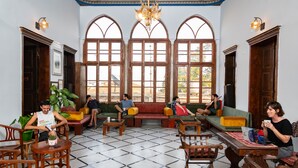 A spacious lobby with a tiled floor, wooden furniture, and large windows. - Fauzi Azar by Abraham (Nazareth)