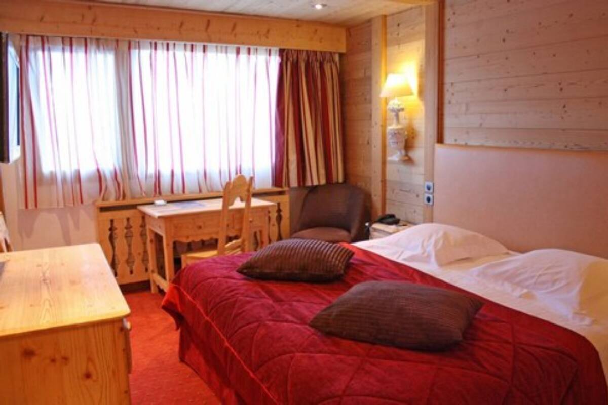 Une chambre à coucher avec un lit, un bureau et une chaise.