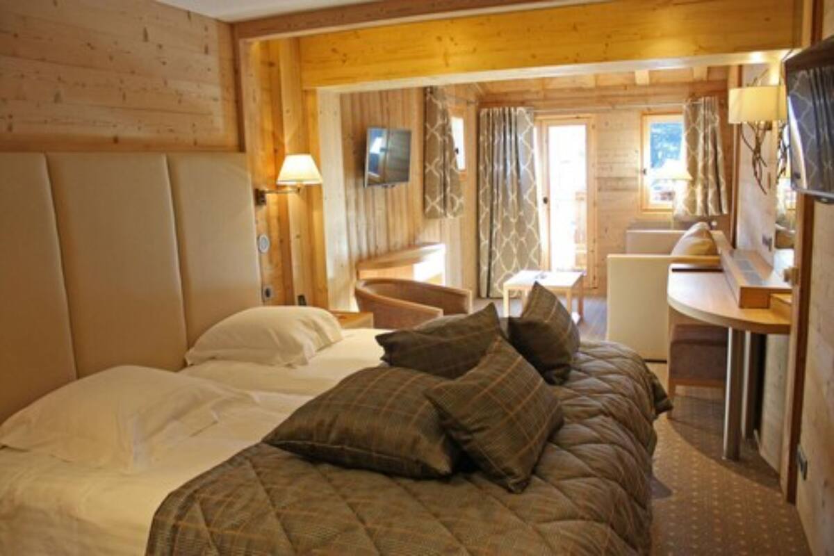 Une chambre confortable dans un chalet en rondins, avec un grand lit, un bureau et une chaise.