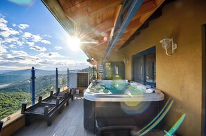 A hot tub on a balcony with a scenic view.