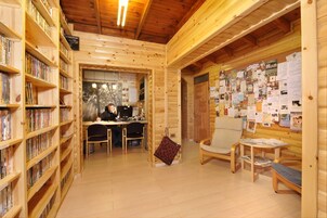 Una cabaña acogedora de madera con estanterías, un escritorio y un tablón de anuncios.