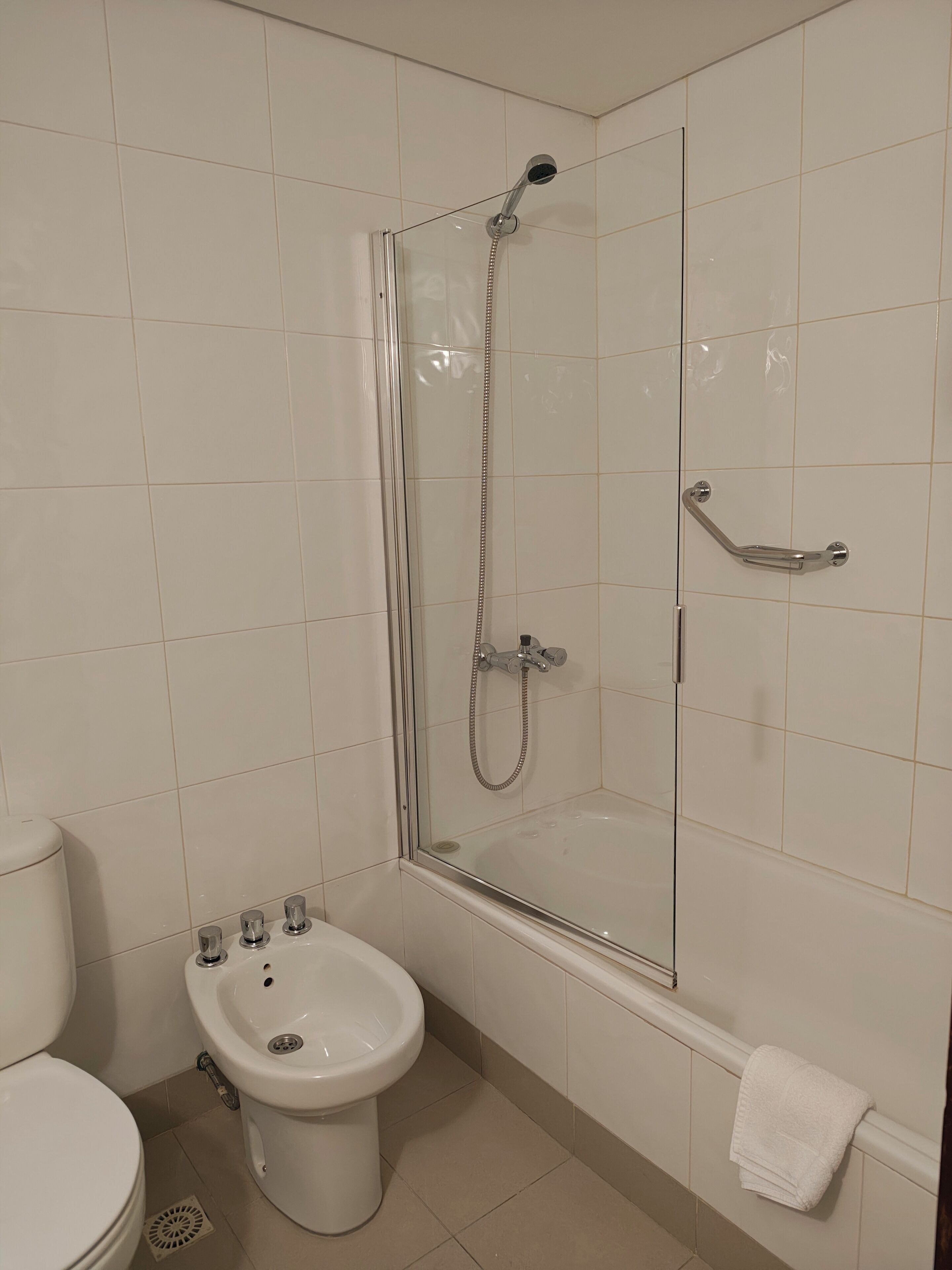 A bathroom with a glass-enclosed shower, a pedestal sink, and a toilet.