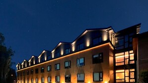 A modern hotel with a row of rooms, a gravel driveway, and a paved walkway.