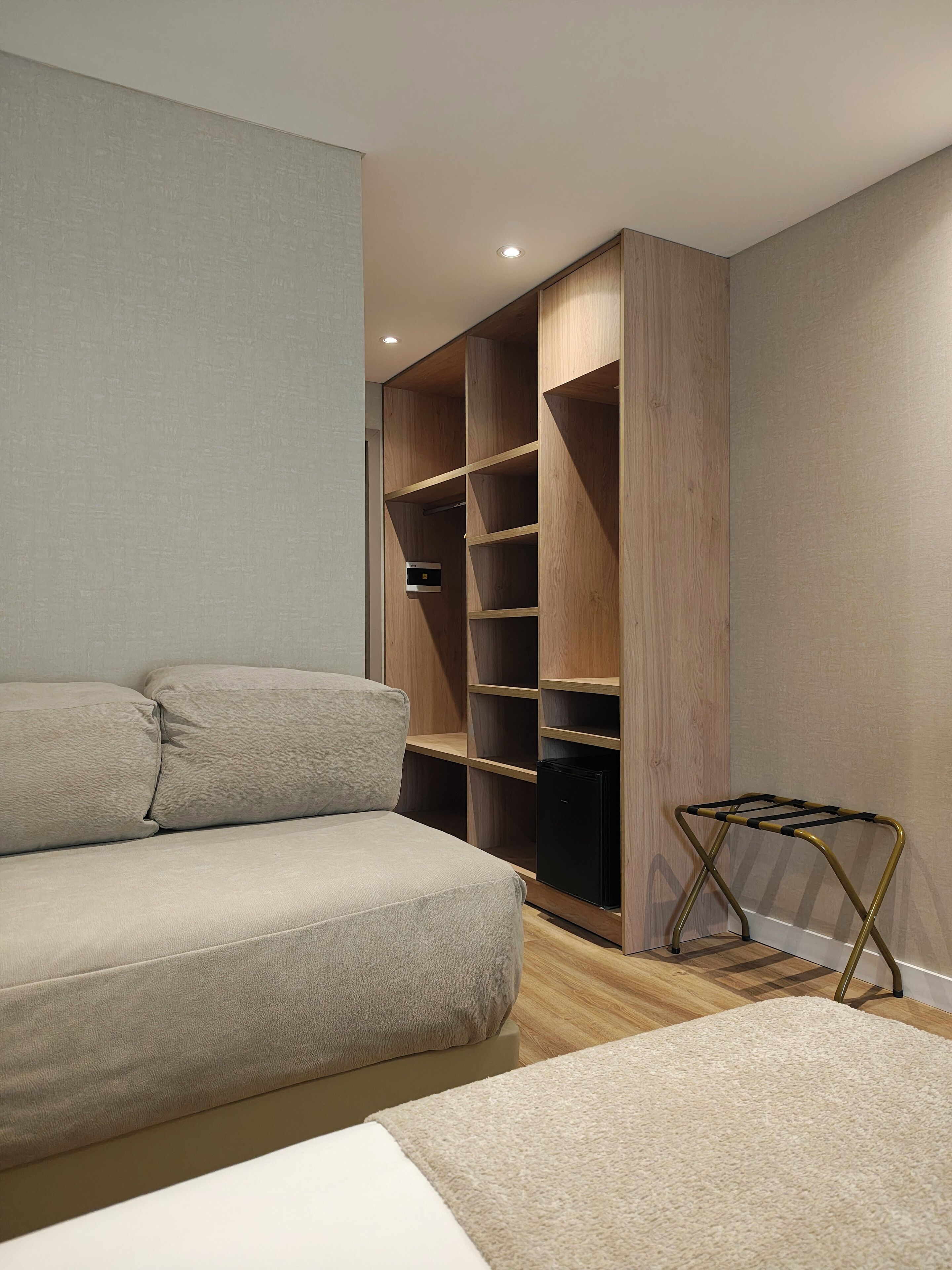 Une chambre moderne avec un placard intégré, un canapé et une petite table.