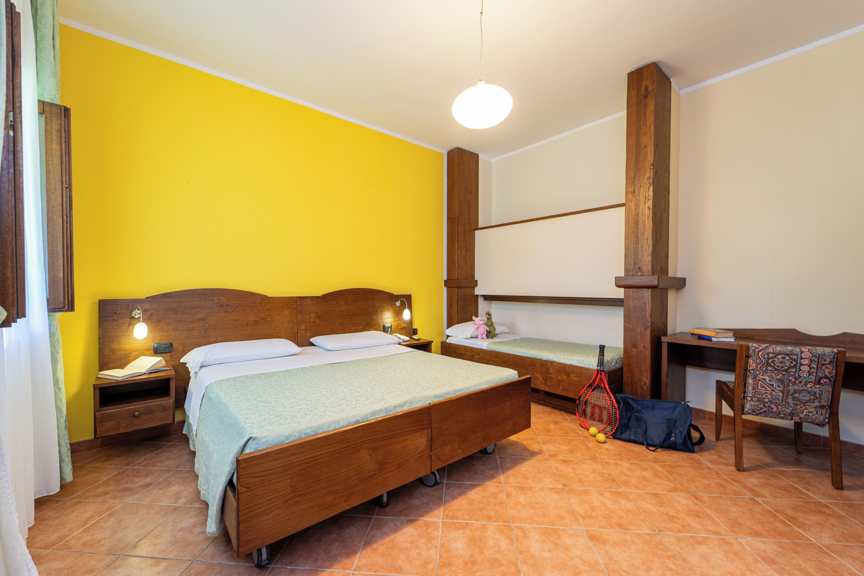 Una habitación con dos camas de madera, un escritorio y una silla.
