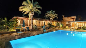 Una piscina al aire libre de temporada, sombrillas