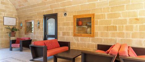 A stone-walled lounge area with sofas and a coffee table.