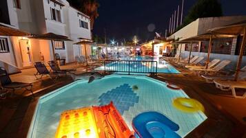 Relax by the pool surrounded by lounge chairs and umbrellas.