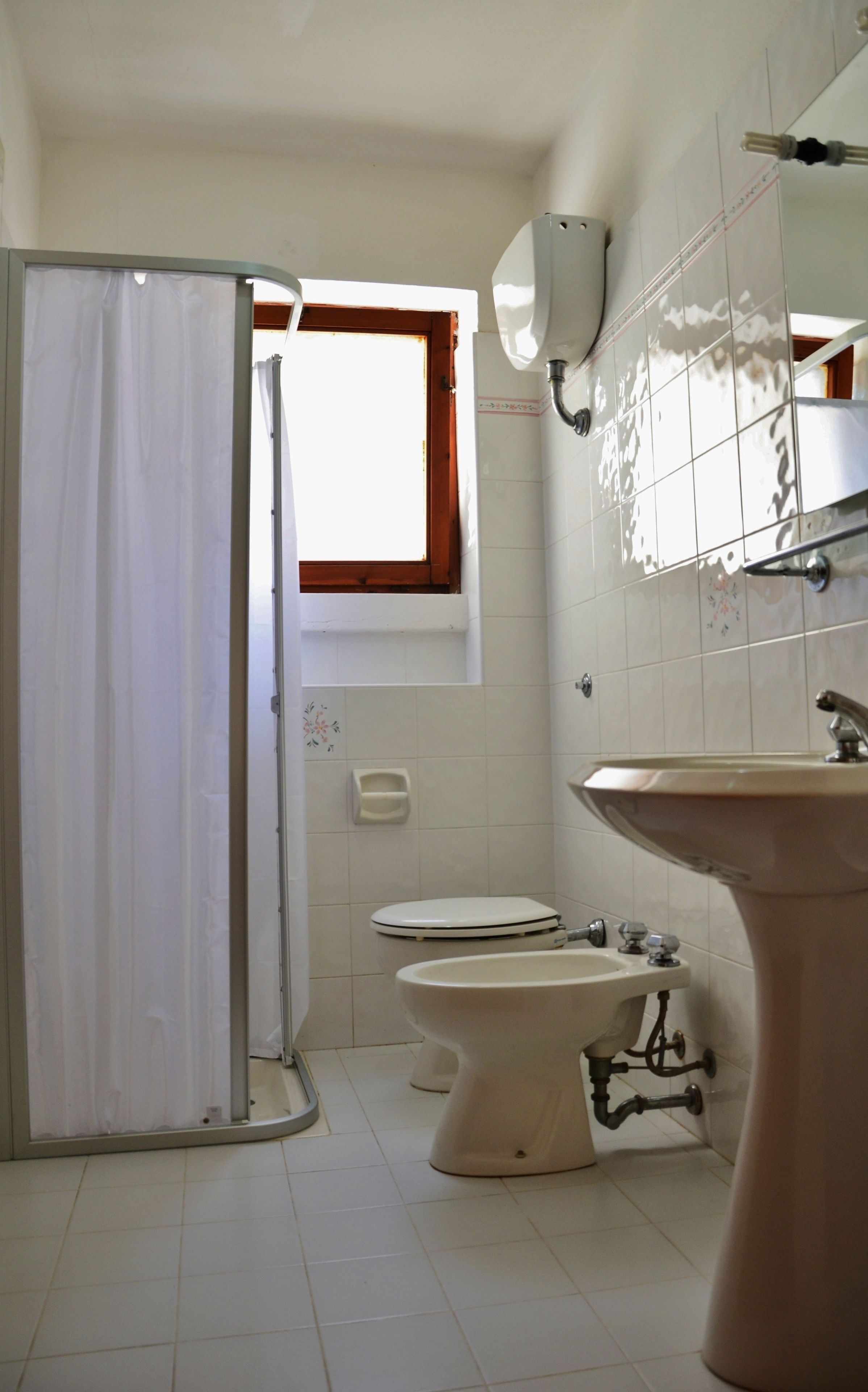 A bathroom with a toilet, bidet, and sink.