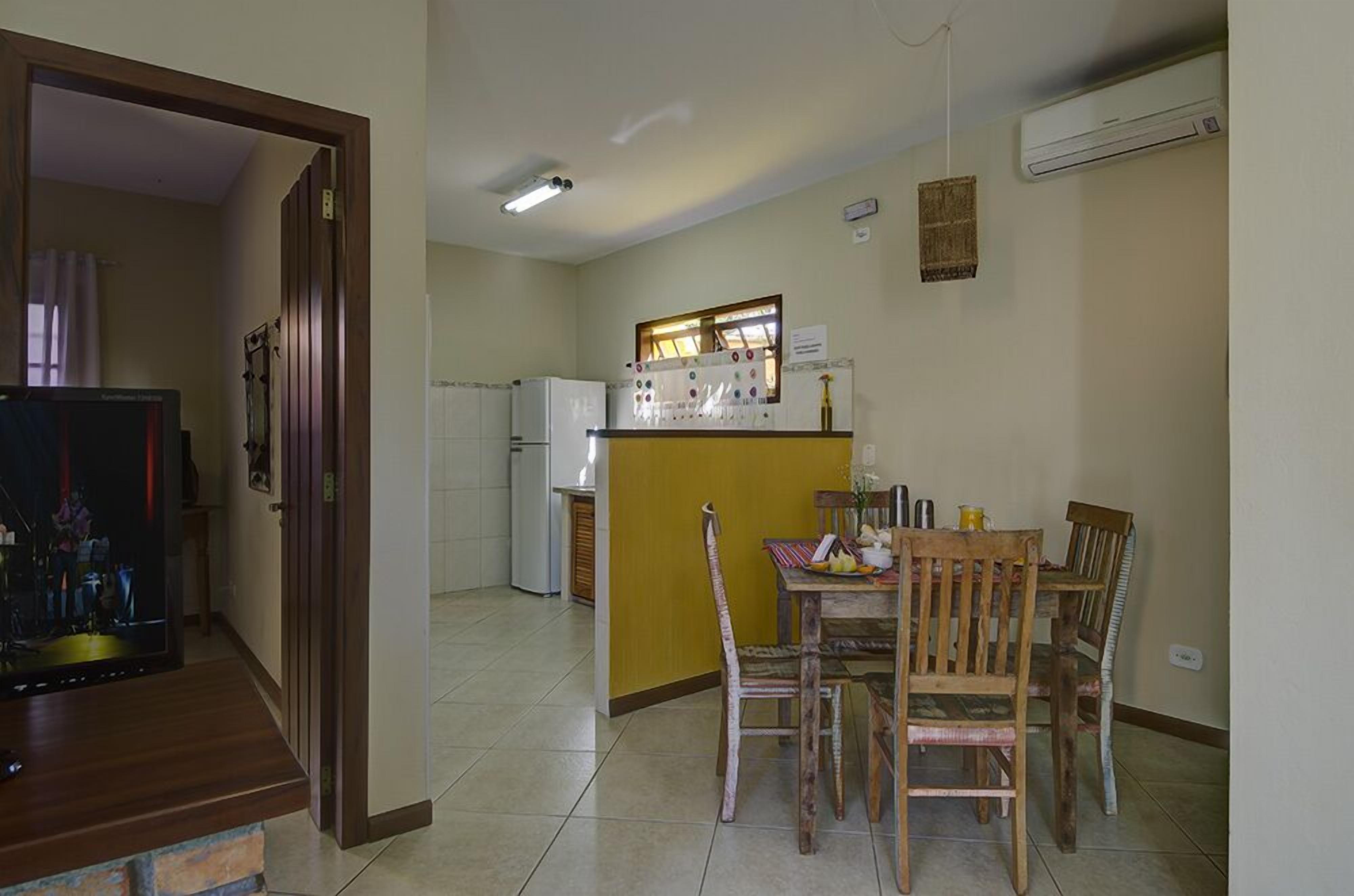 Un espacio habitable compacto con comedor, cocina y televisor en la sala.