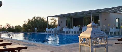 Utomhuspool, parasoller och solstolar