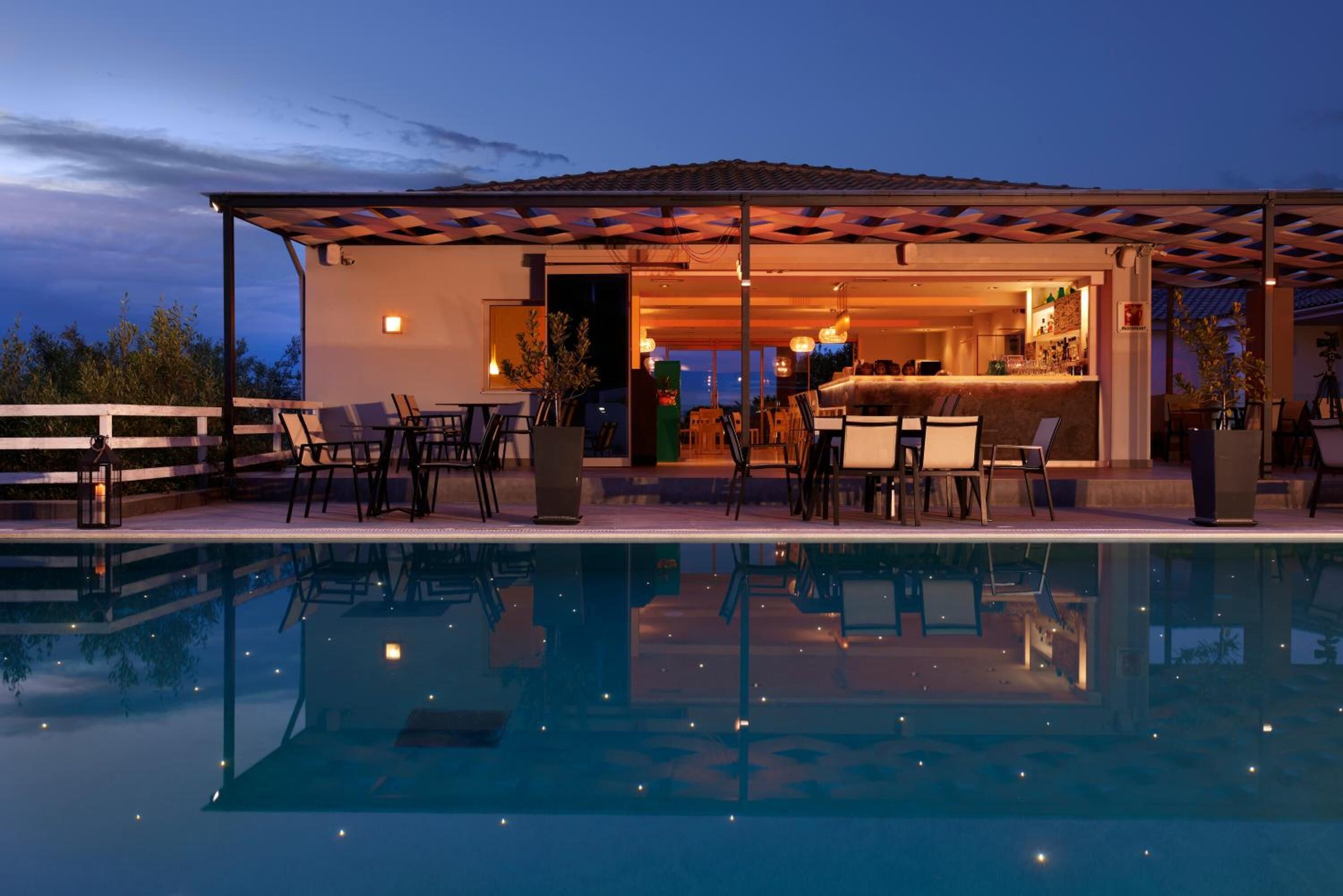 Una piscina al aire libre, sombrillas, sillones reclinables de piscina