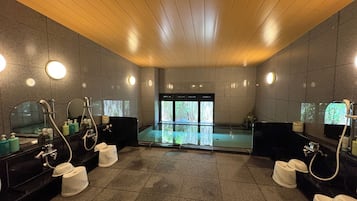 Un baño moderno con varios lavamanos, espejos y zona de ducha.