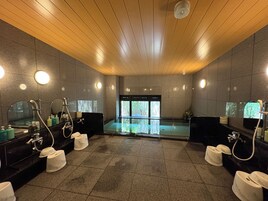 Un baño moderno con varios lavamanos, espejos y zona de ducha.
