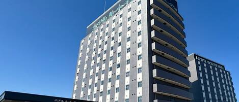 A multi-story hotel building with a modern architectural design, featuring a prominent entrance and signage.