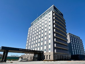 A multi-story hotel building with a modern architectural design, featuring a prominent entrance and signage. - Hotel Route Inn Nagahama Inter (Nagahama)