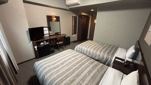 A hotel room with two beds, a desk with a television, a mirror, and an air conditioning unit. - Hotel Route Inn Tokuyama Ekimae (Shunan)