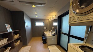 A compact hotel bathroom with a washing machine, a sink, and a small window. - Hotel Route Inn Niihama (Niihama)