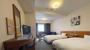 A hotel room with a desk, television, two beds, a chair, and a small table. - Hotel Route Inn Niihama (Niihama)